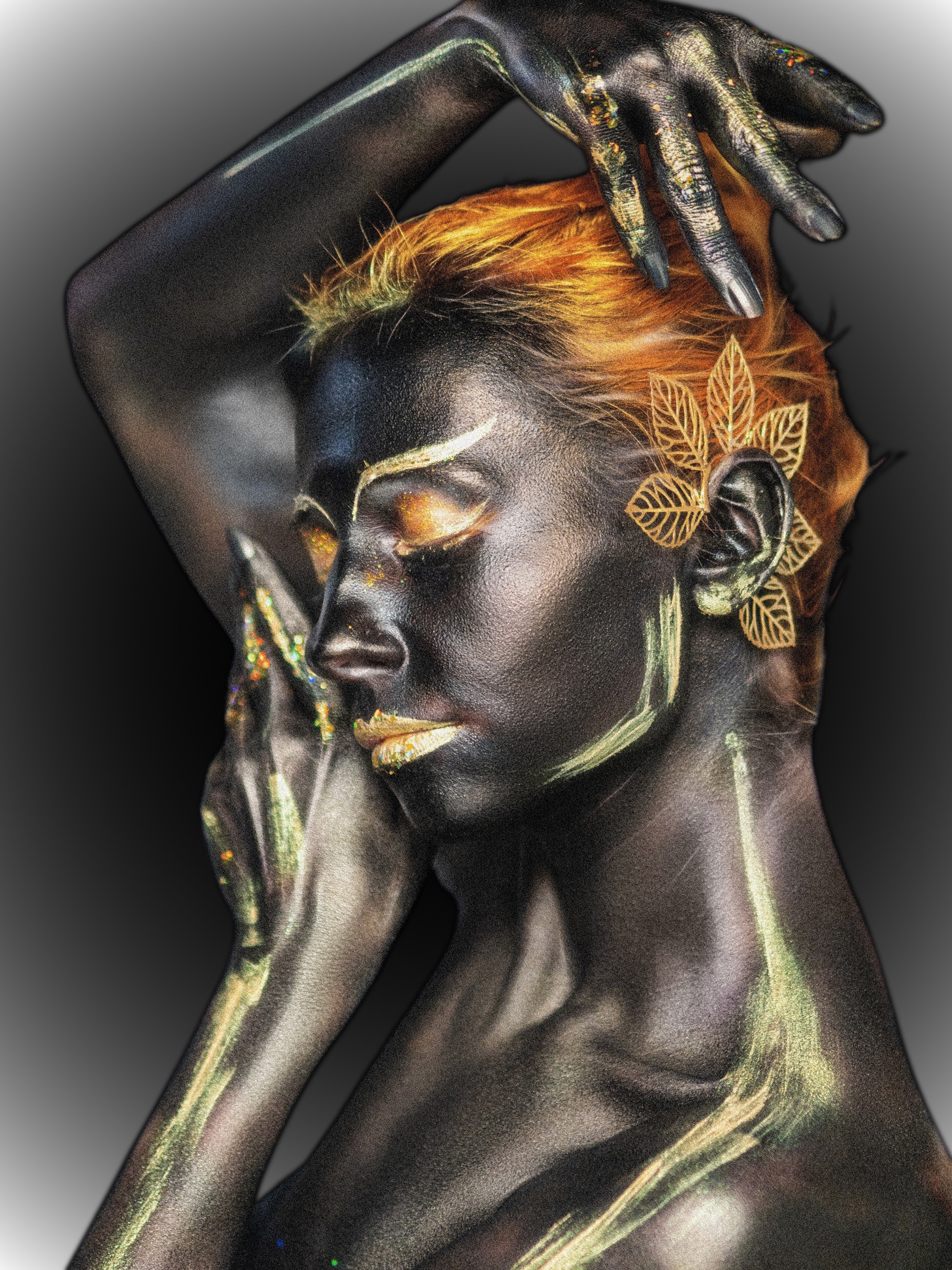 Ethereal artistic portrait of a woman with metallic gold body paint and leaf accents, embodying quiet reflection